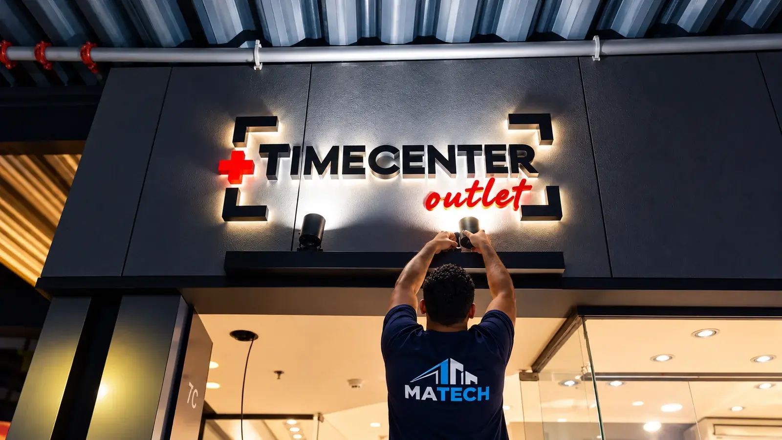 Técnico da MATECH ajustando a iluminação do letreiro de uma fachada comercial